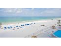 Wide sandy beach with blue lounge chairs, ocean views and a nearby pool at 18500 Gulf Blvd # 406, Indian Shores, FL 33785