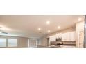 Bright kitchen featuring a large island with granite counters, white cabinets, and stainless steel appliances at 190 Rain Berry Ave, Ruskin, FL 33570