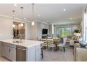 Beautiful open-concept kitchen featuring an island, stainless appliances, and a dining area that flows into the living room at 20423 Symphony Pl, Venice, FL 34293