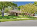 Inviting single-story home showcasing lush greenery, a well-maintained lawn, and attractive stone accents at 2550 Rolling View Dr, Dunedin, FL 34698