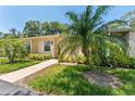 Inviting one-story home showcasing a well-kept lawn and vibrant tropical foliage at 2640 Woodgate Ln # F6, Sarasota, FL 34231