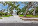 Charming single-story home with mature trees, a spacious driveway, and green lawn at 2662 Oakbrook Dr, Largo, FL 33770