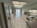Clean kitchen featuring ample white cabinetry, tile floors, and modern appliances at 2826 Rampart Cir, Clearwater, FL 33761