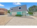 Charming turquoise waterfront home featuring a two-car garage, a paved driveway, and lovely curb appeal at 3021 Alton Dr, St Pete Beach, FL 33706