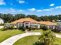 Stunning Mediterranean-style home with a circular driveway, lush landscaping, and a terracotta roof at 304 Hawk Talon Dr, Lithia, FL 33547