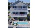 Beautiful house featuring a private pool, multiple balconies, and an outdoor dining area for relaxing waterfront enjoyment at 305 Harbor Dr, Indian Rocks Beach, FL 33785