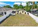 Large grassy backyard with a white vinyl fence, patio furniture, and a screened in porch at 3060 55Th N Ave, St Petersburg, FL 33714