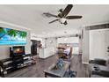 Open-concept living room featuring a ceiling fan, entertainment center, and seamless flow into the kitchen and dining area at 3060 55Th N Ave, St Petersburg, FL 33714