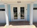 Close-up of the home's inviting double door entry with glass panels and decorative columns at 324 6Th Ave, Indian Rocks Beach, FL 33785