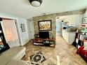 Inviting living room with stone accent wall, wood floors, and open layout to the kitchen at 3970 56Th Ave N, St Petersburg, FL 33714