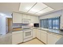 Bright kitchen featuring white cabinets and appliances, offering a functional and inviting space for culinary endeavors at 4017 Moog Rd, Holiday, FL 34691