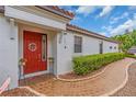Close-up of front entrance featuring a decorative red door and tiled pathway at 4610 Alexandria Ct, Palmetto, FL 34221