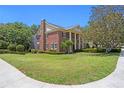 Spacious lawn surrounds this classic brick home, featuring a screened porch and mature trees at 5017 Muir Way, Lithia, FL 33547