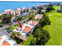 Aerial view of condo complex with red tile roofs, lush green landscaping, and golf course nearby at 5736 La Puerta Del Sol S Blvd # 254, St Petersburg, FL 33715