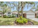 Charming single-story home has a well-manicured lawn and mature trees, creating a welcoming curb appeal at 614 Fayette S Dr, Safety Harbor, FL 34695