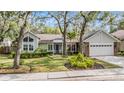 Charming single-story home boasts a well-manicured lawn and mature trees with lush landscaping around the property at 614 Fayette S Dr, Safety Harbor, FL 34695