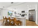 Modern kitchen with white cabinets, stainless steel appliances, quartz countertops, and island with bar seating at 7023 Montauk Point Xing, Bradenton, FL 34212