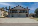 Wide exterior shot of a two story house with stone accents, balcony and three car garage at 7085 Sunset S Dr # A, St Petersburg, FL 33707