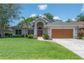 Charming single-story home with a well-manicured lawn, lush landscaping and a two-car garage at 905 Clearcreek Dr, Tampa, FL 33613