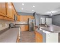 Open kitchen layout with stainless steel appliances, ample counter space, and hardwood floors at 9644 Jasmine Brook Cir, Land O Lakes, FL 34638