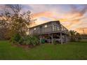 Charming two-story home with a deck and a well-maintained lawn with space for a car underneath the house at 9706 N 22Nd St, Tampa, FL 33612