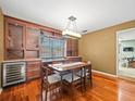 Elegant dining room featuring custom built-ins, a wine cooler, and hardwood flooring at 10206 N Hyaleah Rd, Tampa, FL 33617