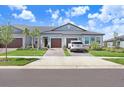 Street view of well-maintained homes featuring a lawn and attached garages at 10998 Gable Dig Loop, San Antonio, FL 33576