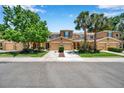 A row of townhomes with well-manicured lawns and mature trees on a sunny day at 11611 Mango Ridge Blvd, Seffner, FL 33584