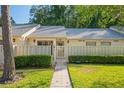 Charming condo with a well-manicured lawn, inviting walkway, and decorative fence at 1300 Shady Pine Way # B, Tarpon Springs, FL 34688