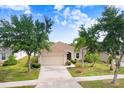Inviting single-story home featuring a well-maintained lawn, mature trees, and a long driveway leading to an attached garage at 13411 Graham Yarden Dr, Riverview, FL 33579