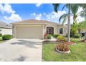 Well-maintained single-story home with an attached garage, manicured lawn, and neatly arranged landscaping at 13411 Graham Yarden Dr, Riverview, FL 33579