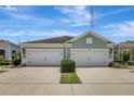 Beautiful home featuring dual garages, green landscaping, and a serene, cloud-filled sky at 13518 Circa Crossing Dr, Lithia, FL 33547