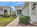 Inviting home featuring well-maintained landscaping and an open porch entryway at 13518 Circa Crossing Dr, Lithia, FL 33547