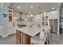 Spacious kitchen with a large marble island, stainless steel appliances, and custom white cabinetry at 14204 Barrington Stowers Dr, Lithia, FL 33547