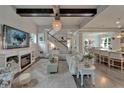 Open-concept living room with fireplace, beamed ceilings, and seamless flow to the kitchen and dining area at 14204 Barrington Stowers Dr, Lithia, FL 33547