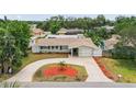 Aerial view of a lovely home featuring a circular driveway, mature trees, and a fenced backyard at 14330 Oliver St, Largo, FL 33774