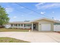 Charming single-story home featuring a well-manicured lawn, neutral color, and an attached two-car garage at 14330 Oliver St, Largo, FL 33774