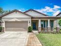 Charming single-Gathering home with a well-manicured lawn, brick walkway, and a two-car garage at 15579 Stone House Dr, Brooksville, FL 34604