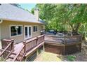 Large wooden deck off the home's rear features a hot tub and outdoor seating area at 16224 Iola Woods Trl, Dade City, FL 33523