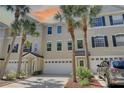Townhouse exterior with palm trees, attached garages, and well manicured landscaping at 29 Seagrape Cir, Clearwater, FL 33759