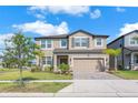 Beautiful two-story home with lush landscaping and a brick-paved driveway at 3113 Marine Grass Dr, Wimauma, FL 33598