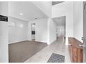 Bright living room showcasing neutral tones and a spacious open floorplan, complemented by tile and carpet flooring at 3113 Marine Grass Dr, Wimauma, FL 33598
