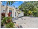 Two-story home featuring a spacious driveway, a two-car garage, and lush tropical landscaping at 3117 W Knights Ave, Tampa, FL 33611