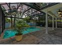 Screened-in pool area with outdoor seating and lush greenery offers a private retreat at 3117 W Knights Ave, Tampa, FL 33611
