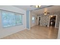 Bright living area showcasing large windows, laminate flooring, and an open flow to the kitchen at 342 N 40Th N St, St Petersburg, FL 33713
