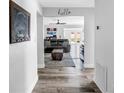 Bright hallway featuring wood-look flooring, leading into a comfortable living space with a stylish black leather sofa at 3537 12Th N Ave, St Petersburg, FL 33713