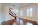 Bright living room featuring hardwood floors, white walls, a staircase, and plantation shutters at 3615 S Church Ave, Tampa, FL 33629