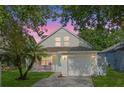 Charming two-story home featuring a well-manicured lawn and a lovely front porch at sunset at 5607 Tanagergrove Way, Lithia, FL 33547