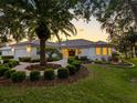 Elegant home exterior with lush landscaping, circular driveway, and decorative lighting at sunset at 5818 Cruiser Way, Tampa, FL 33615
