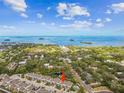 Expansive aerial view of townhomes near a bay with lush surrounding greenery and blue skies at 612 Ozona Village Dr, Palm Harbor, FL 34683